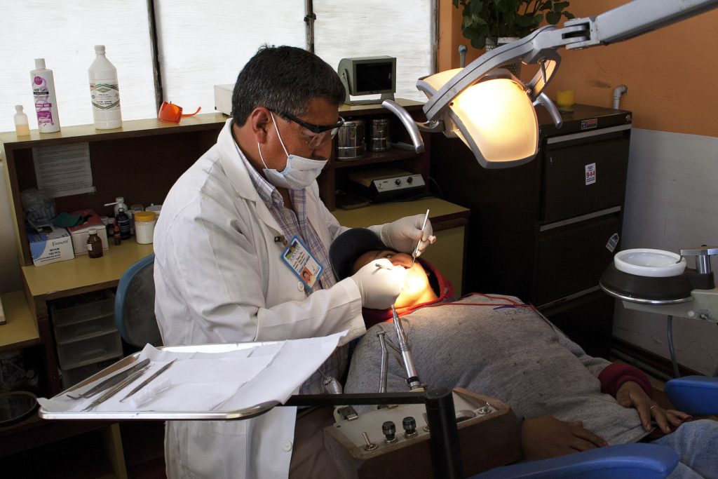Dentist examines worker’s teeth at dental facility built using Fairtrade Premiums