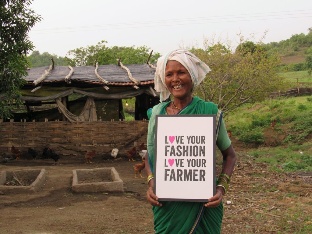 Lingu Bai, Fairtrade cotton farmer and entrepreneur, Adilabad District, Telangana, India. Lingu Bai is with Chetna Organic. She is holding a placard promoting awareness of cotton consumption.
